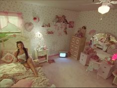 a woman sitting on top of a bed in a room filled with furniture and decor