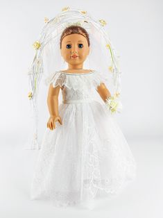 a doll wearing a white dress and veil with flowers on it's head, standing in front of a white background