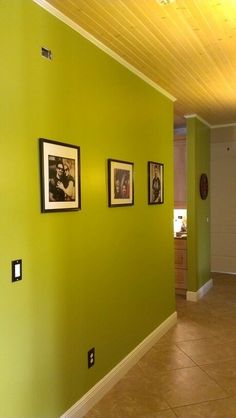 a hallway with green walls and pictures on the wall