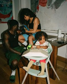 a woman sitting in a high chair next to a child