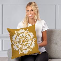 a woman sitting on a couch holding a pillow with an image of two people in the center