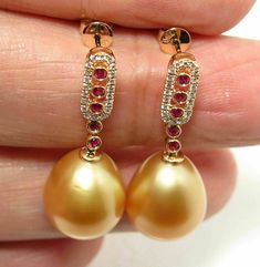 "Gorgeous designed dangle earrings, made of solid 18k yellow gold with 40 pcs. sparkling natural mine diamonds & 10 pcs of natural mine red rubies; plus two organic natural GOLDEN, south sea cultured pearls from Australia. Each of the large 'drop' genuine seawater, \"rich golden\" pearls exhibits excellent high shining luster and thick nacre with just a light natural birthmarks. Style: Dangle. Metal Purity: 18k Solid Yellow Gold. Genuine Diamonds: 40 pcs / 0.179ctw. Genuine Ruby: 10 pcs / 0. 14k Gold Round Pearl Charm Earrings, 14k Gold-filled Pearl Pendant Earrings In Yellow Gold, Nickel-free Yellow Gold Round Pearl Earrings, 14k Yellow Gold-filled Round Pearl Earrings, Hypoallergenic 14k Gold-filled Round Pearl Earrings, 18k Gold Earrings, South Seas, Pearl Types, Ruby Diamond