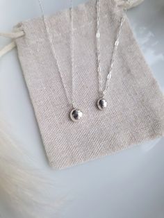 DETAILS  - Small pieces of my recycled silver are melted down to form a ball which is then polished and made into a pendant.  - Each pendant will be unique, average diameter 75mm. If you would like to choose your pendant please do message me as I always have a few in stock.  - Choose from either a simple delicate trace chain, or a hammered chain (the larger chain in photos). - If you have any questions about necklace length or require an extension chain do let me know. The necklaces in photos me Silversmithing Jewelry, Pebble Pendant, Pebble Necklace, Eco Friendly Jewelry, Jewelry Card, Recycled Silver, Recycled Sterling Silver, Necklace Handmade, Organza Bags