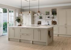 a large kitchen with white cabinets and wood flooring is pictured in this image from the front view