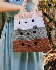 a woman is holding a crocheted bag with cats on it