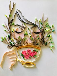 a woman's face is made out of paper with flowers and leaves on it