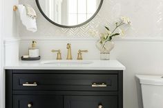 a white and black bathroom with gold accents