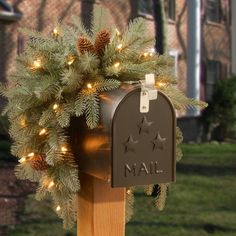 a mailbox decorated with pine cones and lights