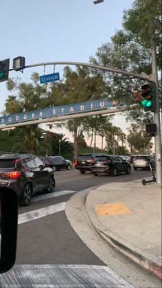 cars are driving under an overpass on a street in front of a building and palm trees