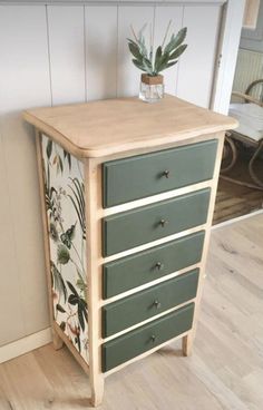 a green and white dresser sitting on top of a hard wood floor next to a wall