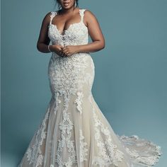 a woman in a wedding dress posing for the camera with her hands on her hips