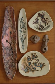 three different types of decorative plates on a wooden table with flowers and plants painted on them