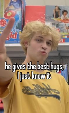 a man with blonde hair giving the peace sign while he gives the best hugs i just know