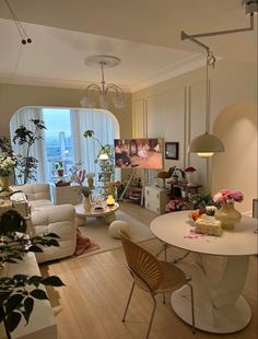 a living room filled with furniture next to a window covered in plants and potted plants