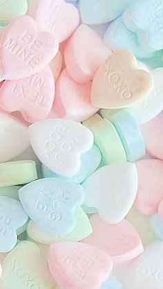 pastel candy hearts are scattered on top of each other