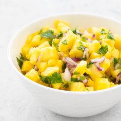 a white bowl filled with pineapple and onions