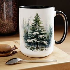 a coffee mug sitting on top of a wooden table next to a spoon and cup