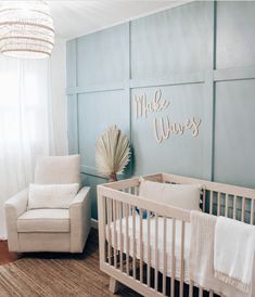 a baby's room with blue walls and white furniture