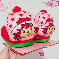 two strawberry shortcakes are sitting on top of a pink card with red hearts