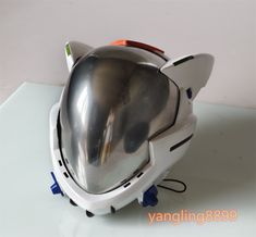 a silver helmet sitting on top of a white table