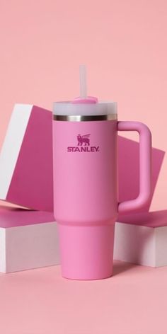 a pink coffee cup with a straw in it sitting on top of a white box