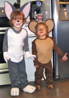 two children dressed up as mice in front of an oven with their faces painted white