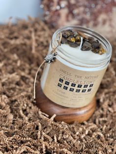 a jar filled with seeds sitting on top of wood shavings