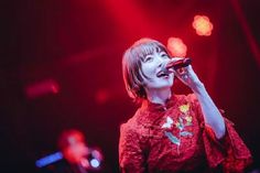 a woman singing into a microphone on stage