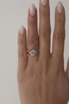 a woman's hand with a ring on it and a diamond in the middle