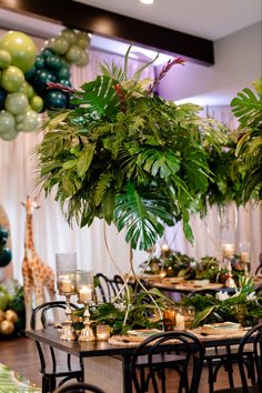 a jungle themed party with balloons and greenery