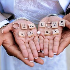 two people holding their hands with the words love story spelled on them in scrabble letters