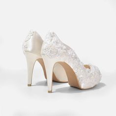 a pair of white wedding shoes with lace on the toes and heels are shown against a white background