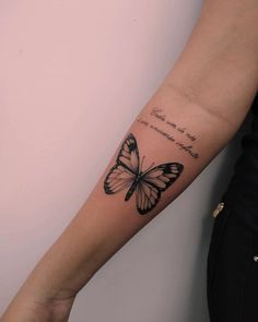 a woman's arm with a butterfly tattoo on the left side of her arm