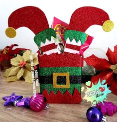 a candy box decorated like a santa hat and elf's head with christmas decorations around it