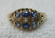 Quality early Edwardian 18ct solid gold diamond and sapphire gemstone ring. The head of the ring is marquise shaped, size 10.0mm{North to South} x 12.0mm{East to West} and is encrusted with rows of light blue sapphire gemstones and diamond gemstone chips. All of the gemstones are in top condition and exposed to the ring's reverse side to allow the light to shine through to make them glow, also for easy cleaning access. The shank is straight and displays a full striking Birmingham 18ct gold assay hallmark for the year 1903 on its inside circumference. Size 'R-S'{UK}, 9.25{US}. Weighs 3.1 grams. Superb condition throughout with genuine precious gemstones, no repairs and full authentication for its year of manufacture --- a pretty Edwardian example. Antique Oval Sapphire Ring With Single Cut Diamonds, Victorian Gold Sapphire Ring With Diamond, Victorian Sapphire Ring With Diamond In Gold, Victorian Sapphire Ring With Diamond For Formal Occasions, Heirloom Marquise Yellow Gold Sapphire Ring, Formal Victorian Sapphire Ring Accented With Diamonds, Heirloom Marquise Sapphire Ring In Yellow Gold, Heirloom Sapphire Diamond Ring With Rose Cut, Formal Marquise Sapphire Ring With Rose Cut Diamonds