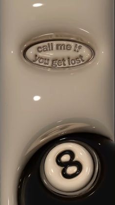 a white toilet with a black and white eight ball on it's side, which says call me if you get lost