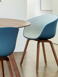 two blue chairs sitting next to each other on top of a wooden table