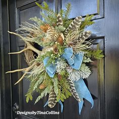 a wreath on the front door decorated with pine cones and feathers