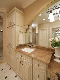 a large bathroom with marble counter tops and white cabinets