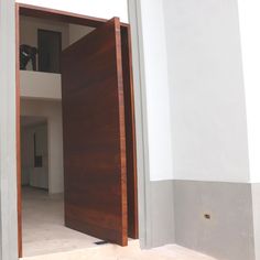 an open wooden door in a white room