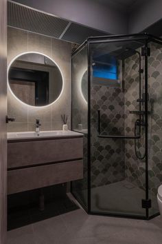 a bathroom with a toilet, sink and shower stall in the middle of the room