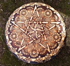 a decorative wooden plate sitting on the ground