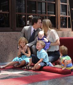 a man and woman kiss their children on the hollywood walk of fame