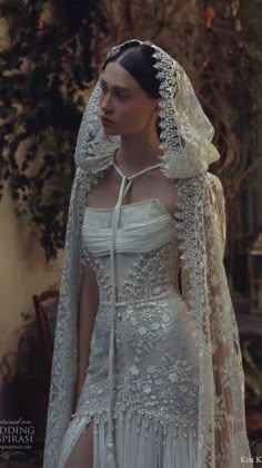 a woman in a white wedding dress with a veil on her head and long sleeves