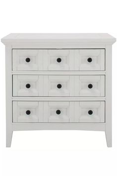 a white chest of drawers with black knobs