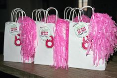 three white bags with pink streamers on them