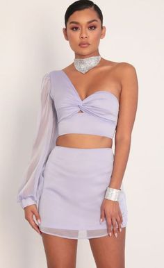 Strut your stuff in this lovely and unique two piece set. Featuring a trendy one shoulder with mini puff detailing, front twist neckline, chiffon tie-back for closure and a classy a-line skirt. Made in our flowy two-tone chiffon in lavender that makes this set dainty, yet edgy. Wear together or separate by pairing with your favorite high waisted jeans. Take this set from day to night by pairing with crystal jewelry and knee-high booties. 

	 

	Made In Los Angeles 

	- Tie-back De Purple Two Piece, Co Ords Outfits, Dreamy Gowns, Purple Skirt, Dress Sketches, Crop Top Outfits, High Waisted Jeans, Two Piece Set, Two Piece Outfit