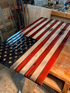 an american flag made out of wood sitting on top of a wooden table in a shop