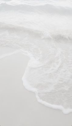 two people walking on the beach with surfboards