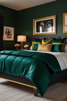 a bed with green comforter and pillows in a bedroom next to two pictures on the wall